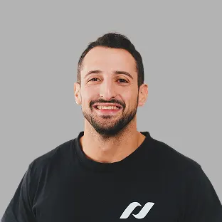Colaborador de Neocoast con remera negra con logo institucional, posando sonriente.