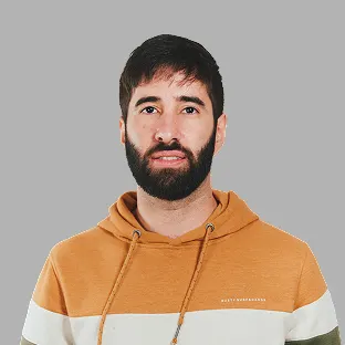 Miembro del equipo de Neocoast con buzo marrón claro, posando con barba y expresión neutra.
