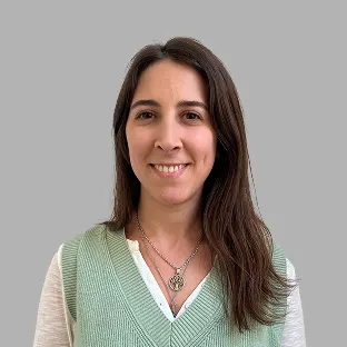 Integrante del equipo de Neocoast con blusa verde claro y sonrisa cálida frente a fondo gris neutro.