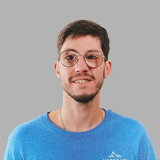 Colaborador de Neocoast con gafas redondas y remera azul, posando con expresión relajada.