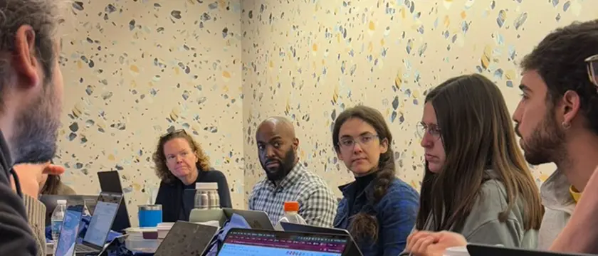 Reunión del equipo ThinkCERCA con laptops en una mesa de trabajo