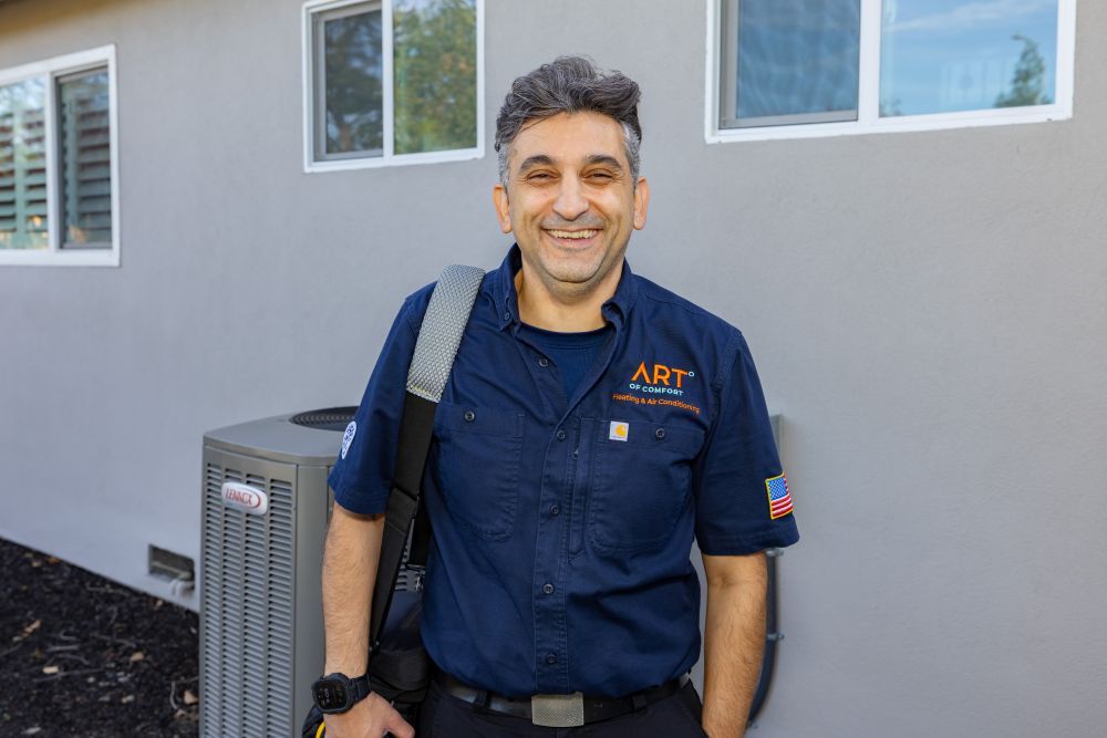 Art of Comfort technician outside, right in front of condenser unit