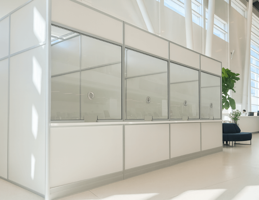 Teilen white framed glass wall system dividing a bright open office