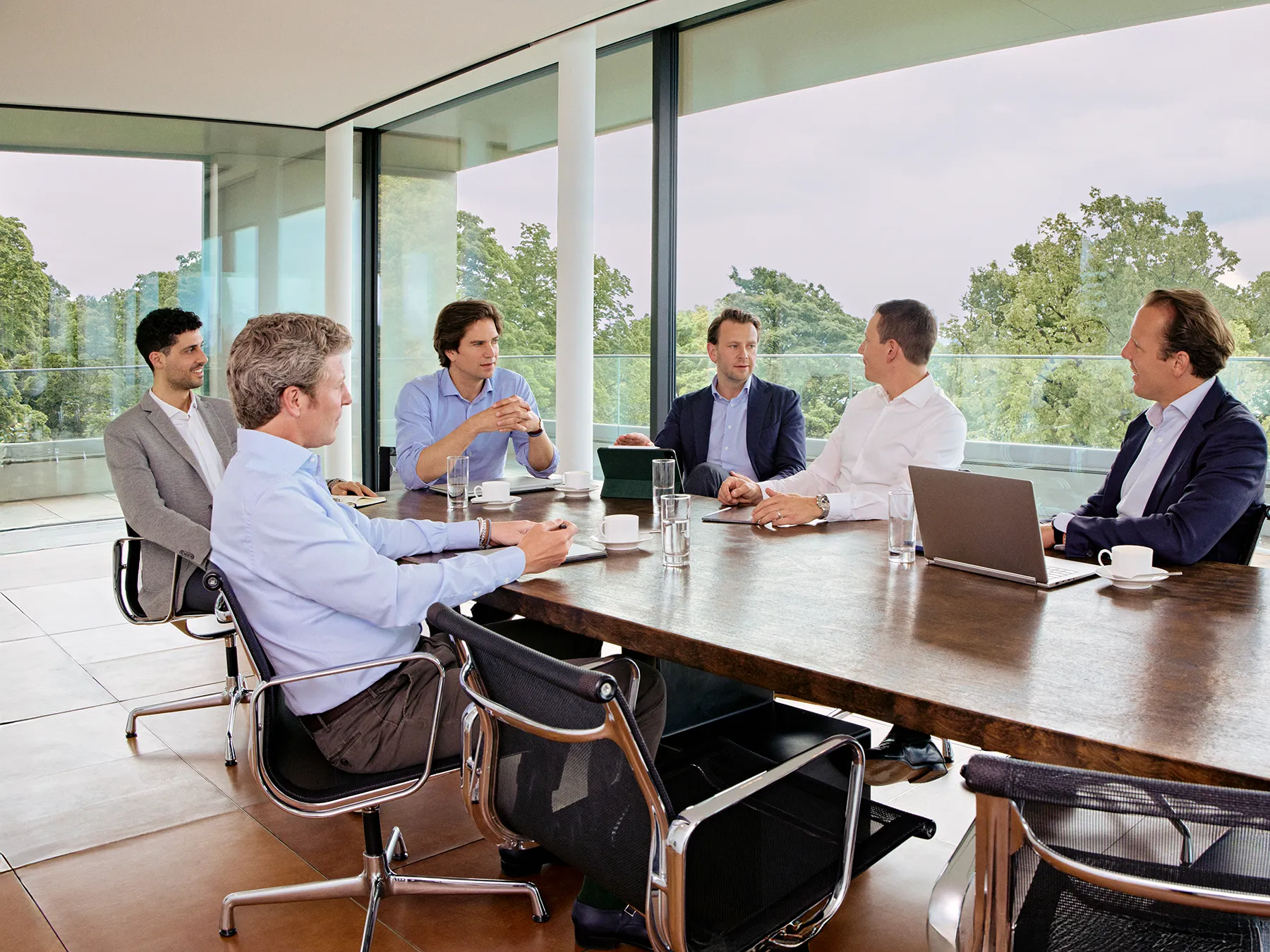 Team von Companion Kapital bei einer Besprechung am Konferenztisch in modernem Meetingraum.