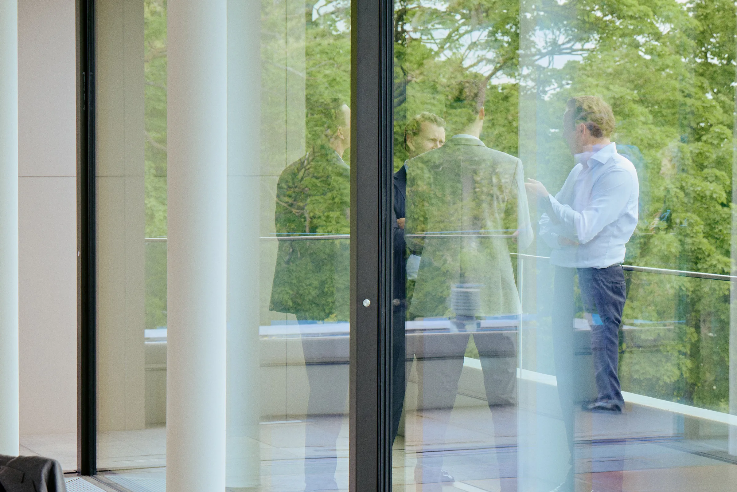 Das Team von Companion Kapital im Dialog – aufgenommen durch die Fensterfront in einer offenen, lichtdurchfluteten Büroszene.