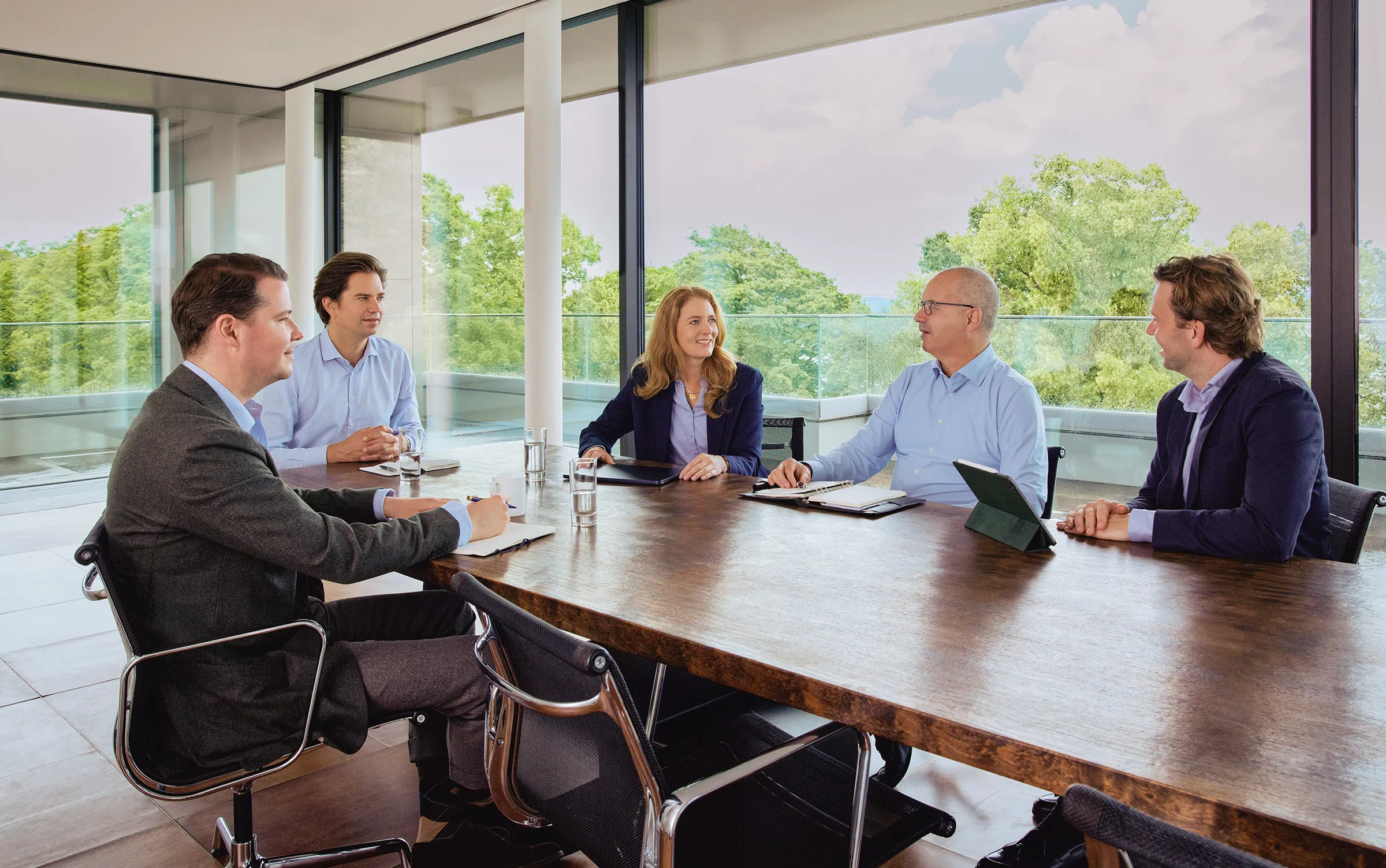 Team von Companion Kapital bei einer Besprechung am Konferenztisch in modernem Meetingraum.