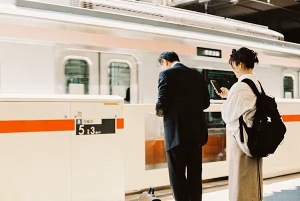 People wait for a train at the station platform.