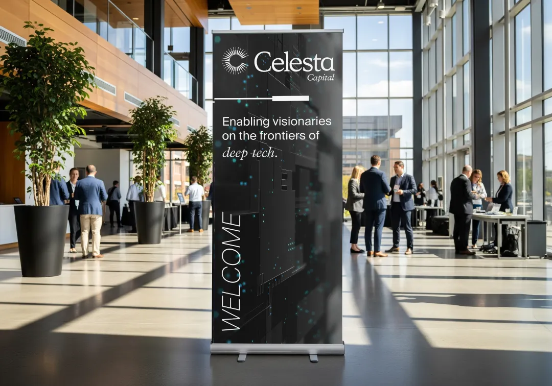 Conference area with large windows and tall plants, featuring a black banner for Celesta Capital reading 'Enabling visionaries on the frontiers of deep tech' and 'WELCOME' vertically.