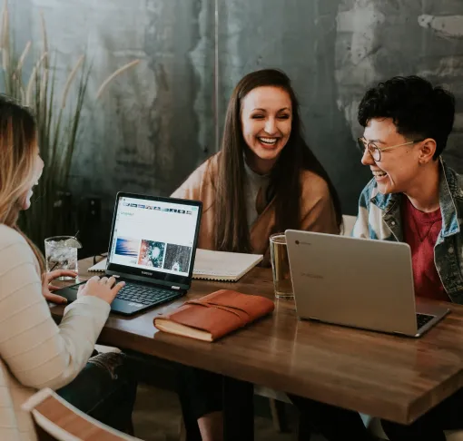 Thee women with laptops having a meeting working at coffee shop