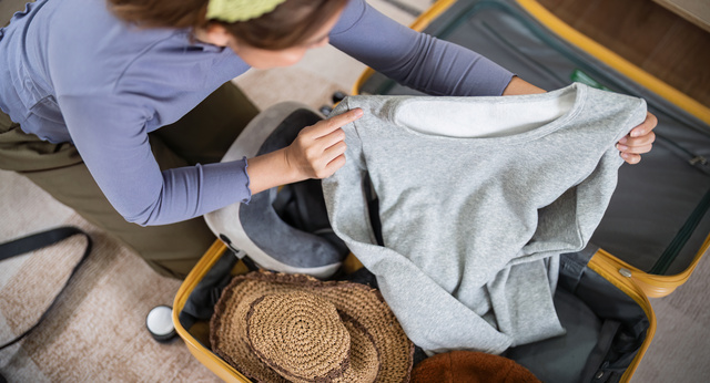 Woman unpacking clothes from luggage