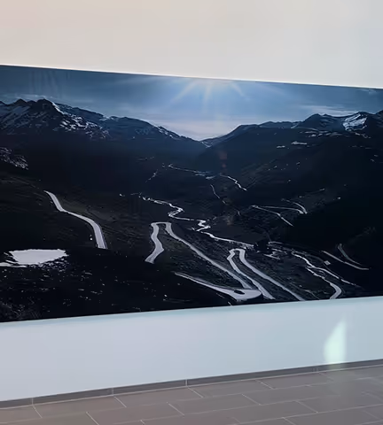 Stort veggbilde med fjellandskap og svingete vei.