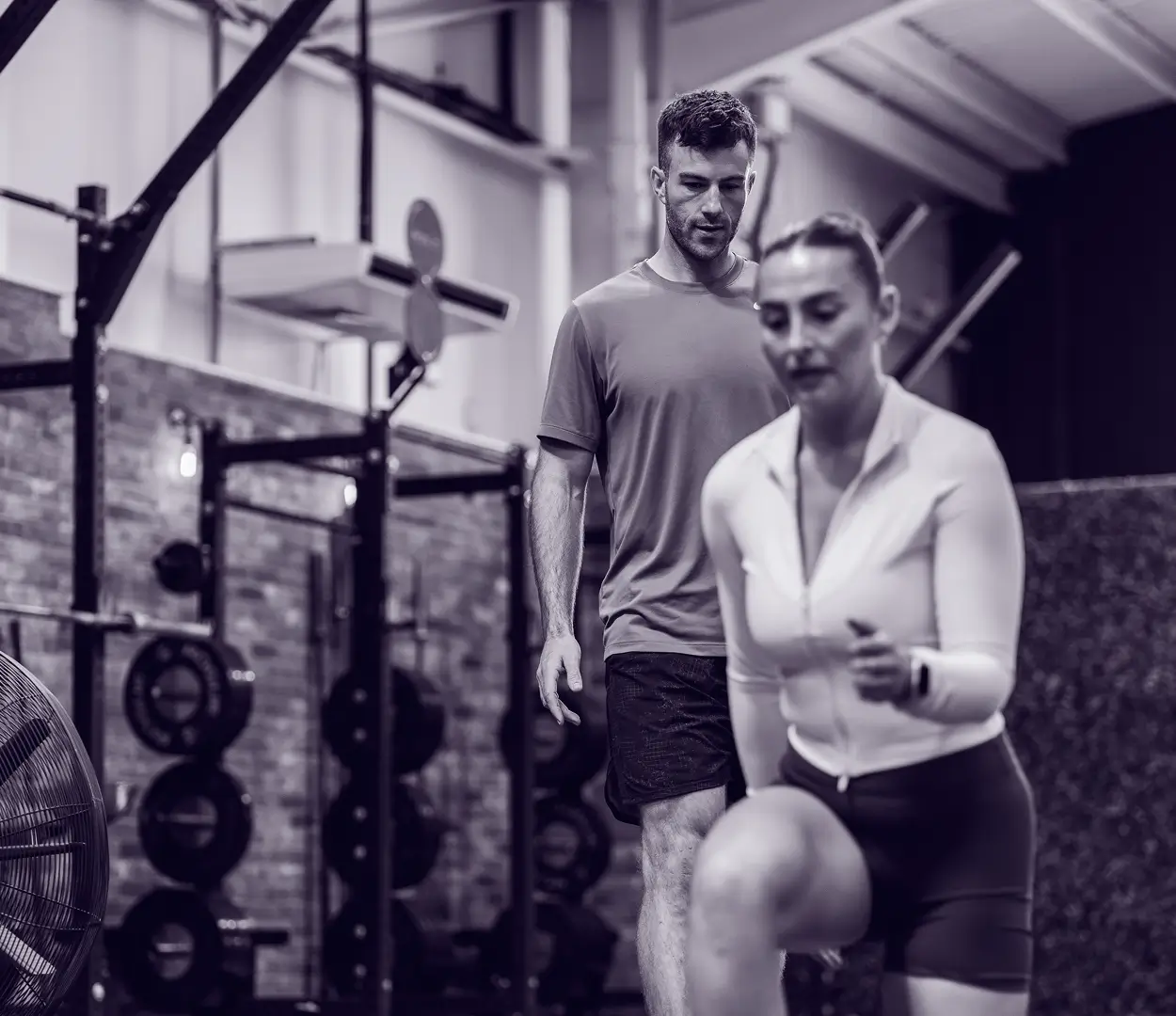 Personal trainer teaching a student in a gym