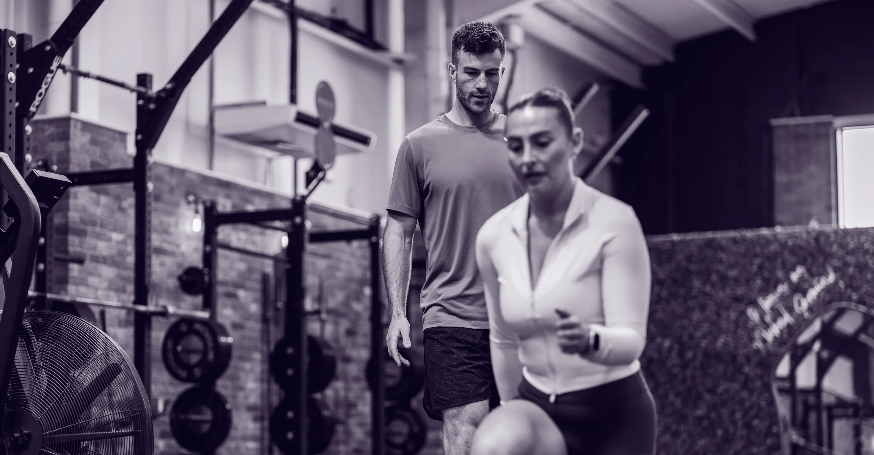 Personal trainer teaching someone in a gym