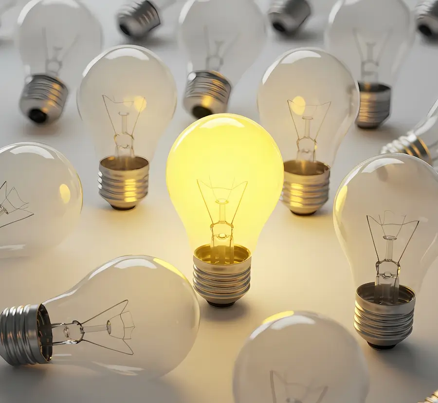 One bright light-bulb stands out against many unlit bulbs to show excellence