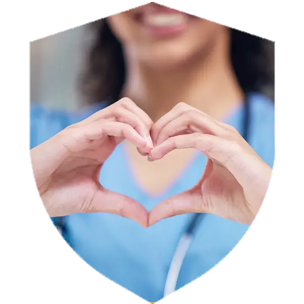 A nurse in blue scrubs holds their hands up in the shape of a heart