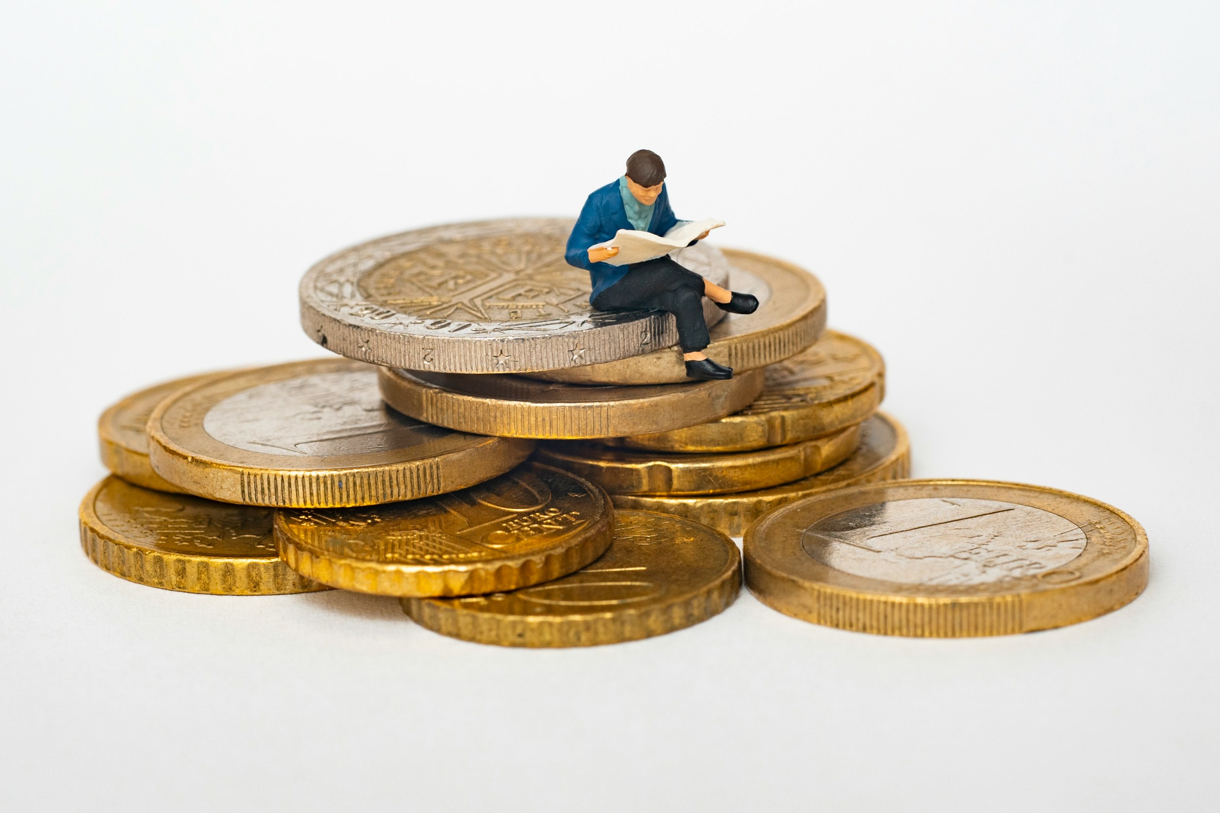 person sitting on coins - How Much Do Funded Traders Make