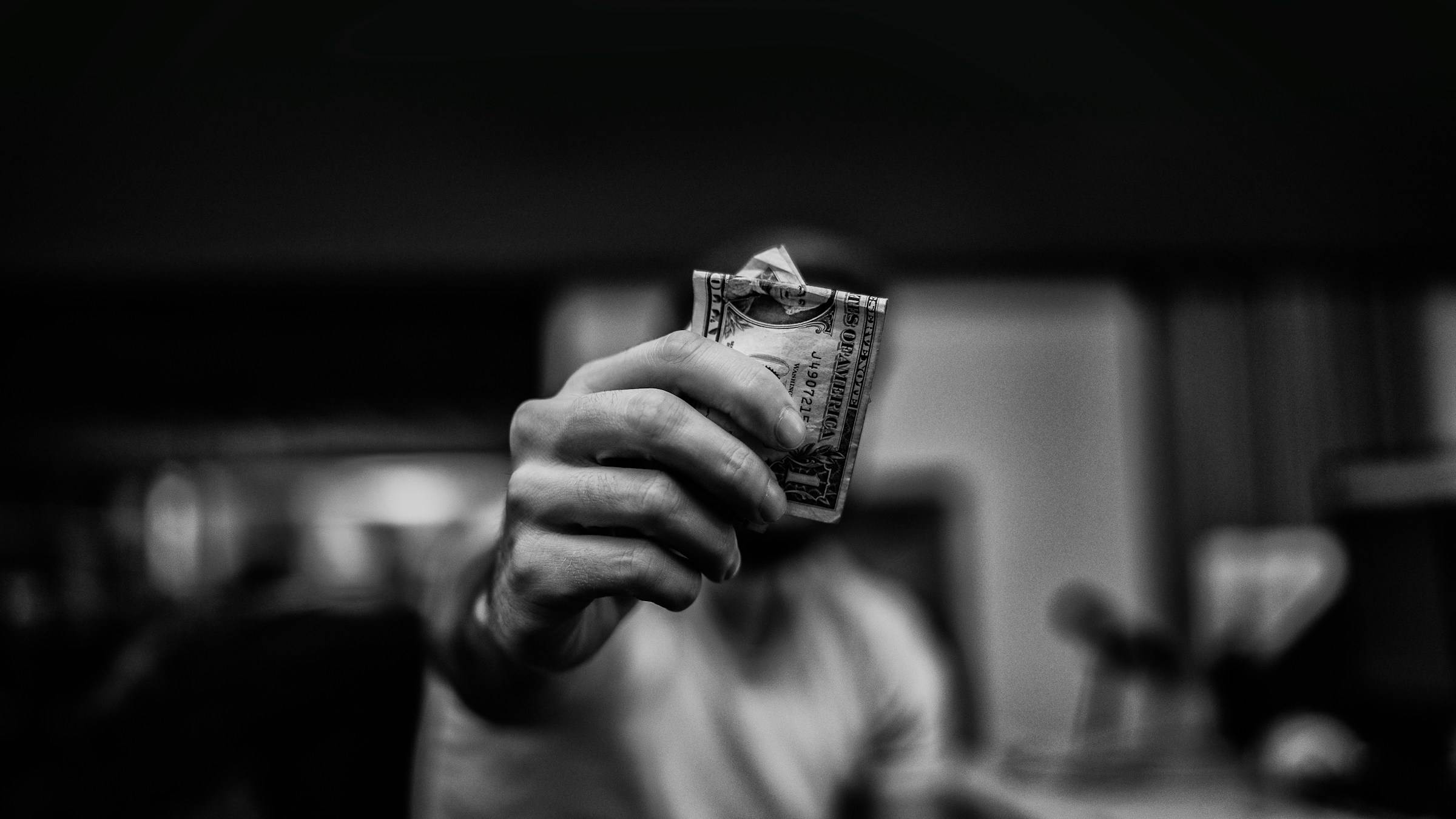 man holding a dollar bill - Prop Firm Challenges