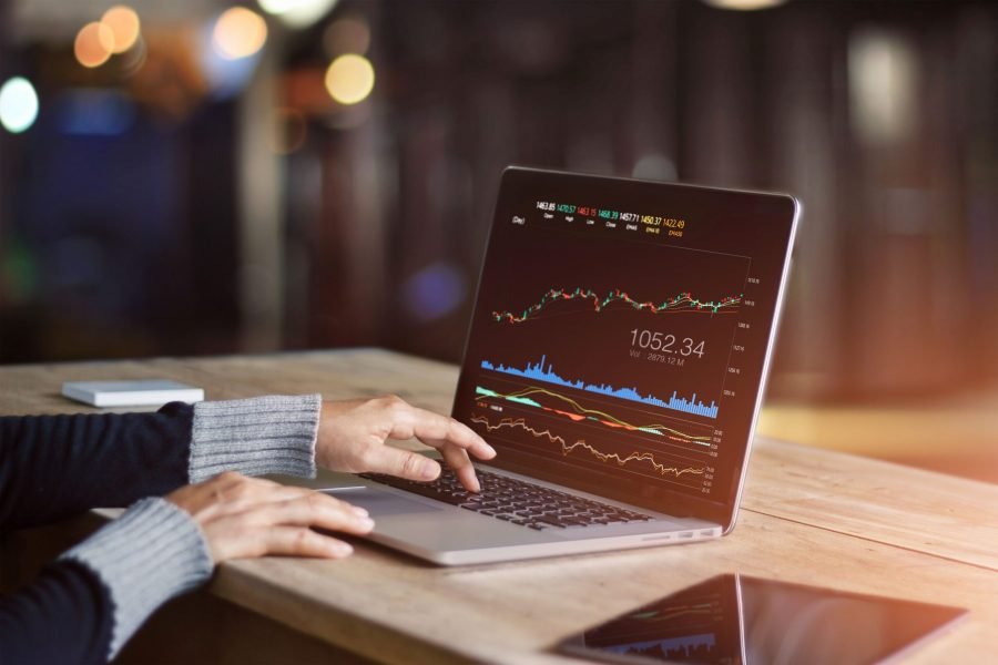 woman with a trading chart on a laptop - How Much To Start Day Trading
