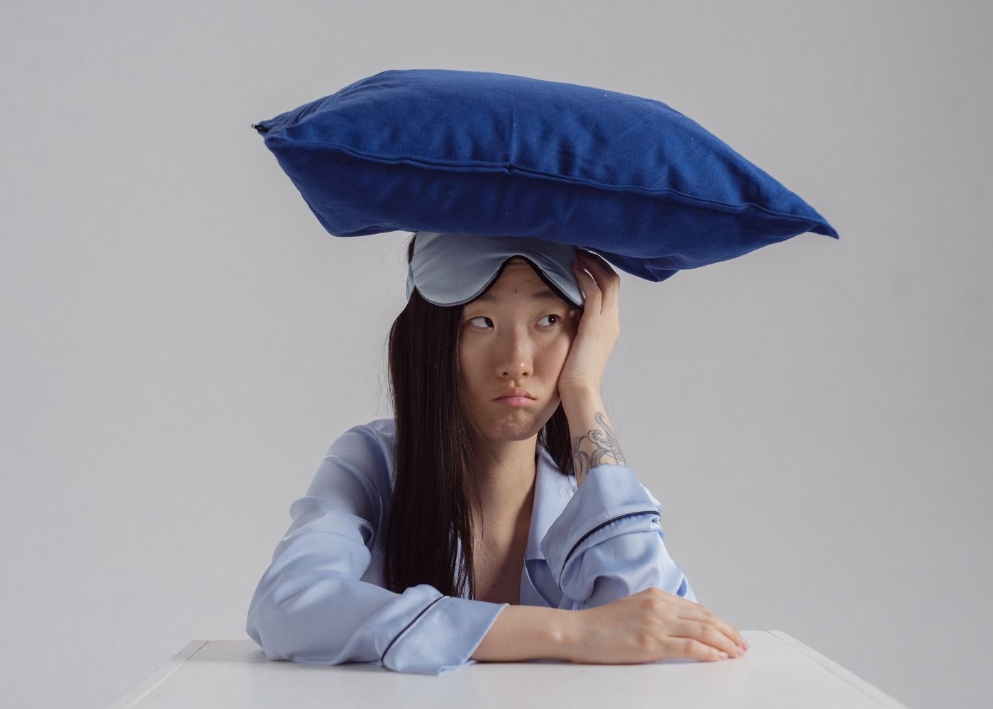 Femme avec un oreiller sur la tete illustrant les problèmes de sommeil