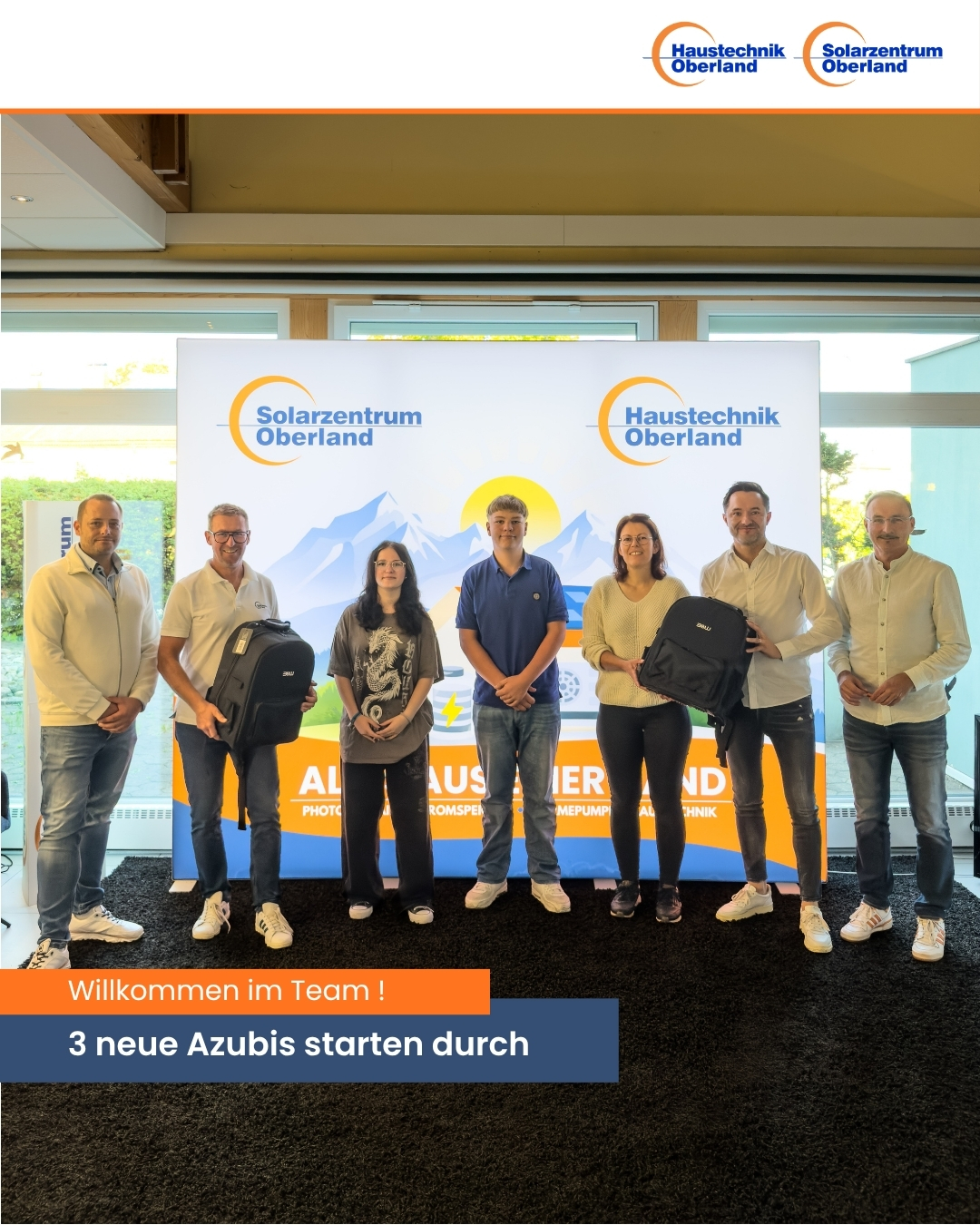 7 Personen stehen auf einer Bühne und begrüßen die neuen Azubis bei Solarzentrum Oberland.