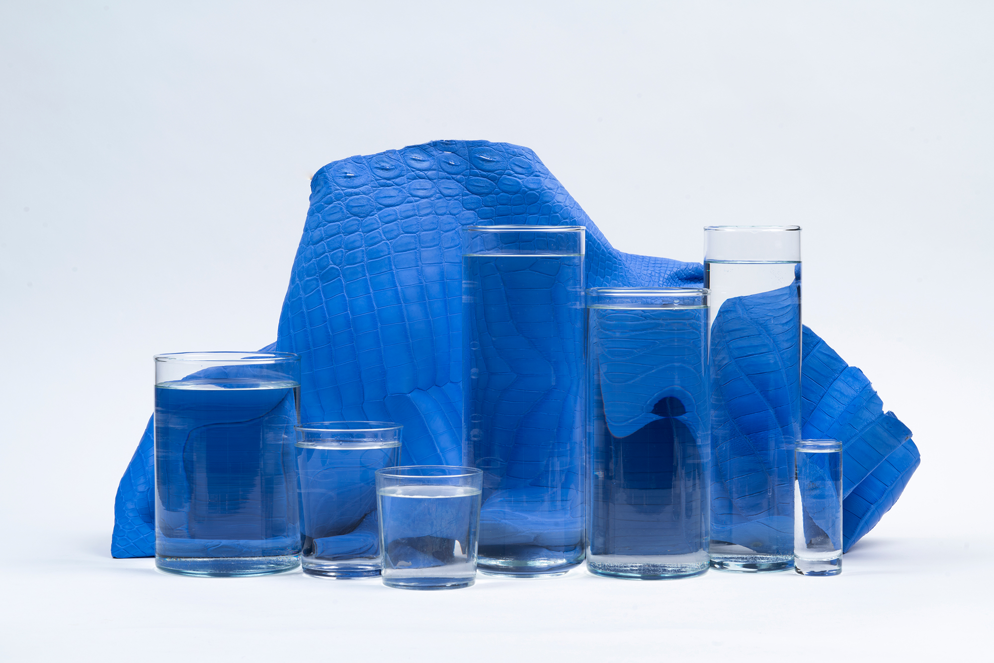 A close-up view of brown leather with a crocodile skin pattern, showcasing the texture and intricate details of the raised scales.