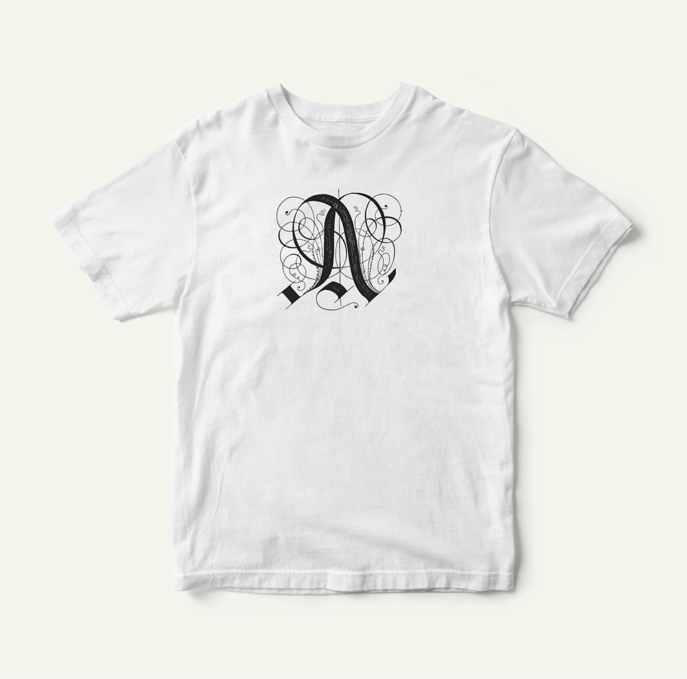 White T-shirt with an ornamental written "A" in black on the front.