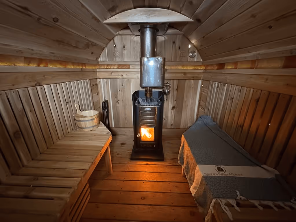 A wooden room with a stove inside of it.
