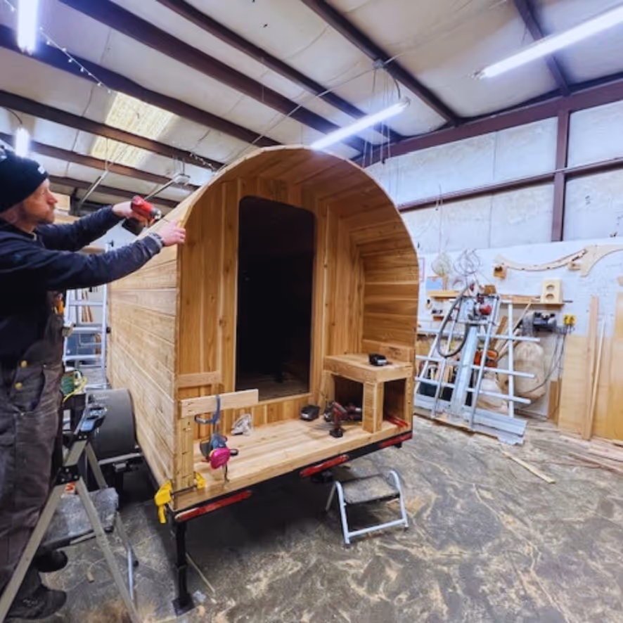 A man working on a wooden structure in a building.