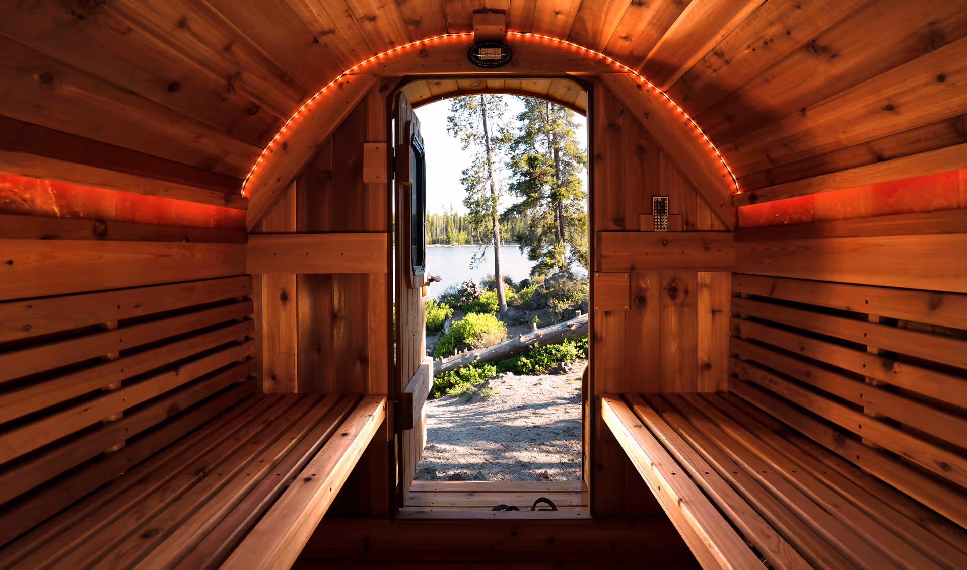 A wide-angle shot looking down the length of an empty, clean barrel sauna from the entrance.