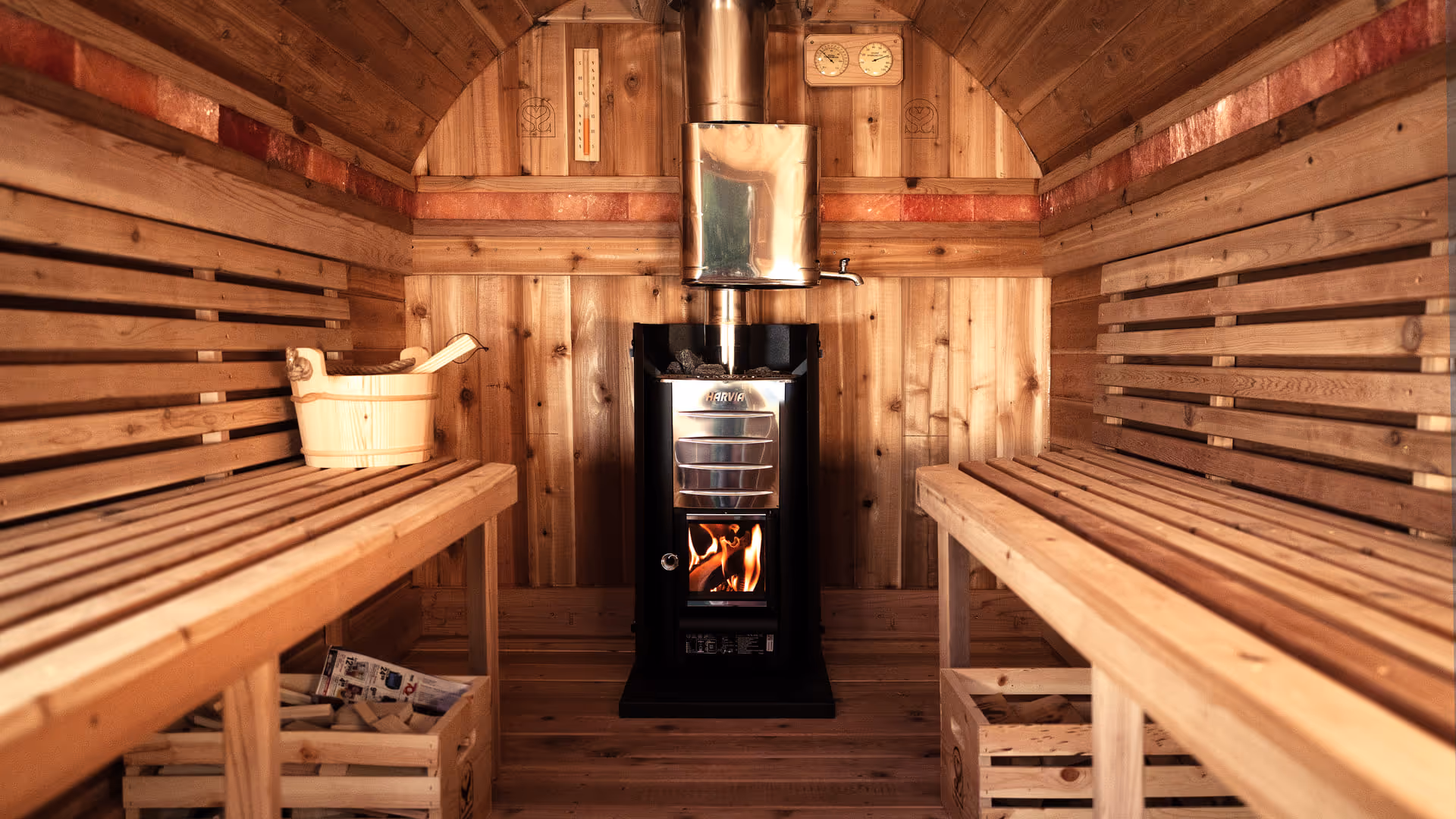 The interior corner of a wooden sauna, showing the benches and warm lighting on the wood panels.