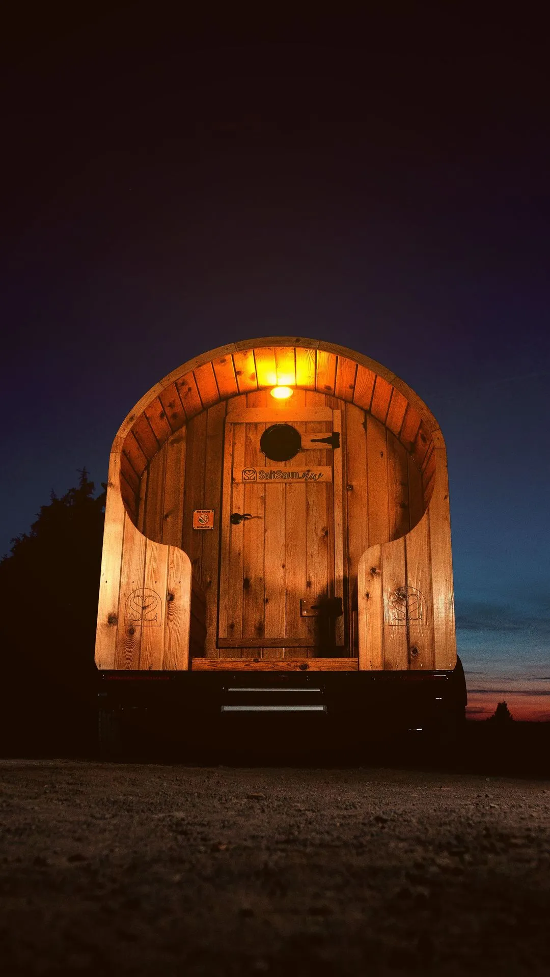 The serene and empty interior of a barrel sauna, warmly lit to highlight the wooden craftsmanship.