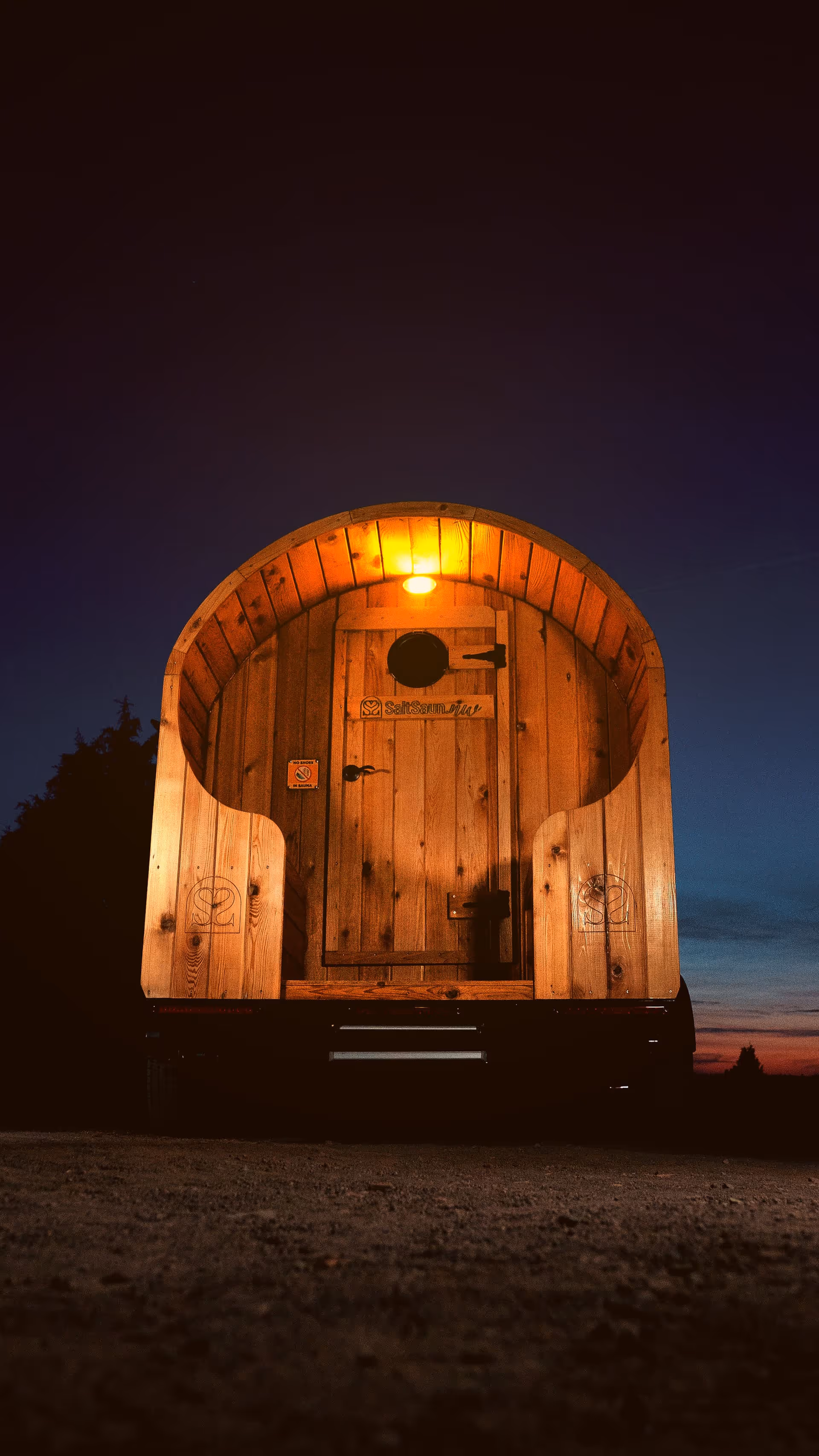 The serene and empty interior of a barrel sauna, warmly lit to highlight the wooden craftsmanship.
