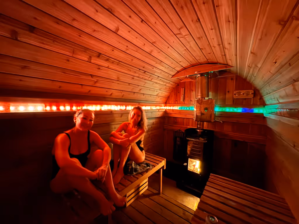 A couple of women sitting in a sauna.