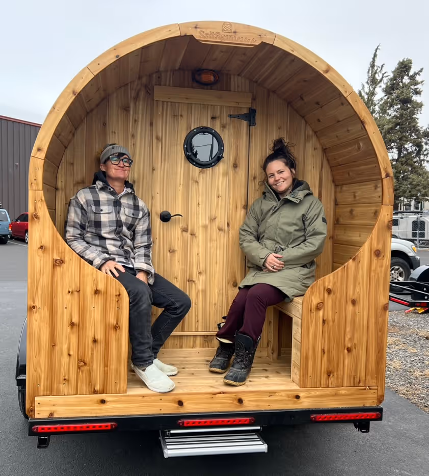 A couple of people sitting inside of a wooden structure.