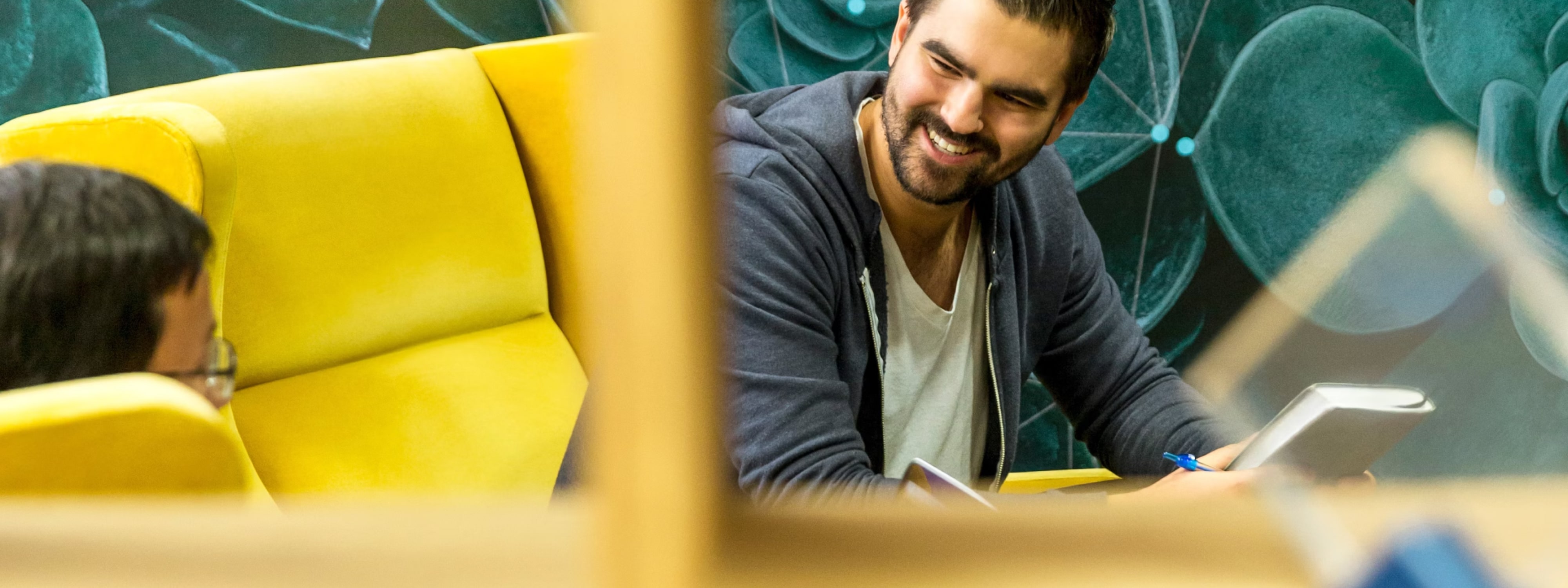 Smiling man working at a desk with a tablet and notes – Farika wholesale collaboration CTA banner