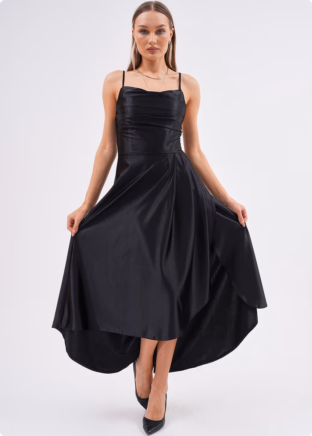Model wearing a black satin evening gown with spaghetti straps and a high-low hemline – Farika collection.