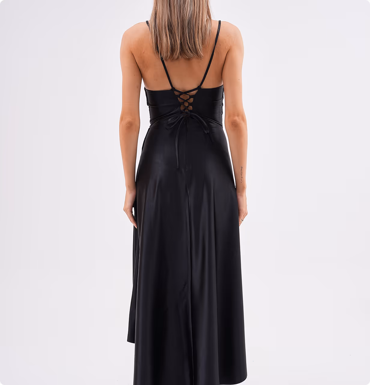 Back view of model wearing Celestera gown, showcasing the lace-up back design and flowing satin fabric.