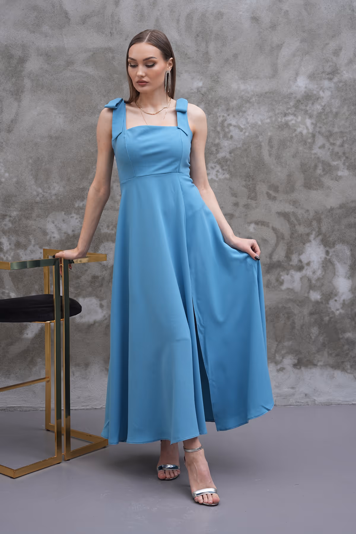 Front-facing view of the Celina sky blue dress, showcasing its sleek bodice, wide straps with bows, and flowy silhouette.
