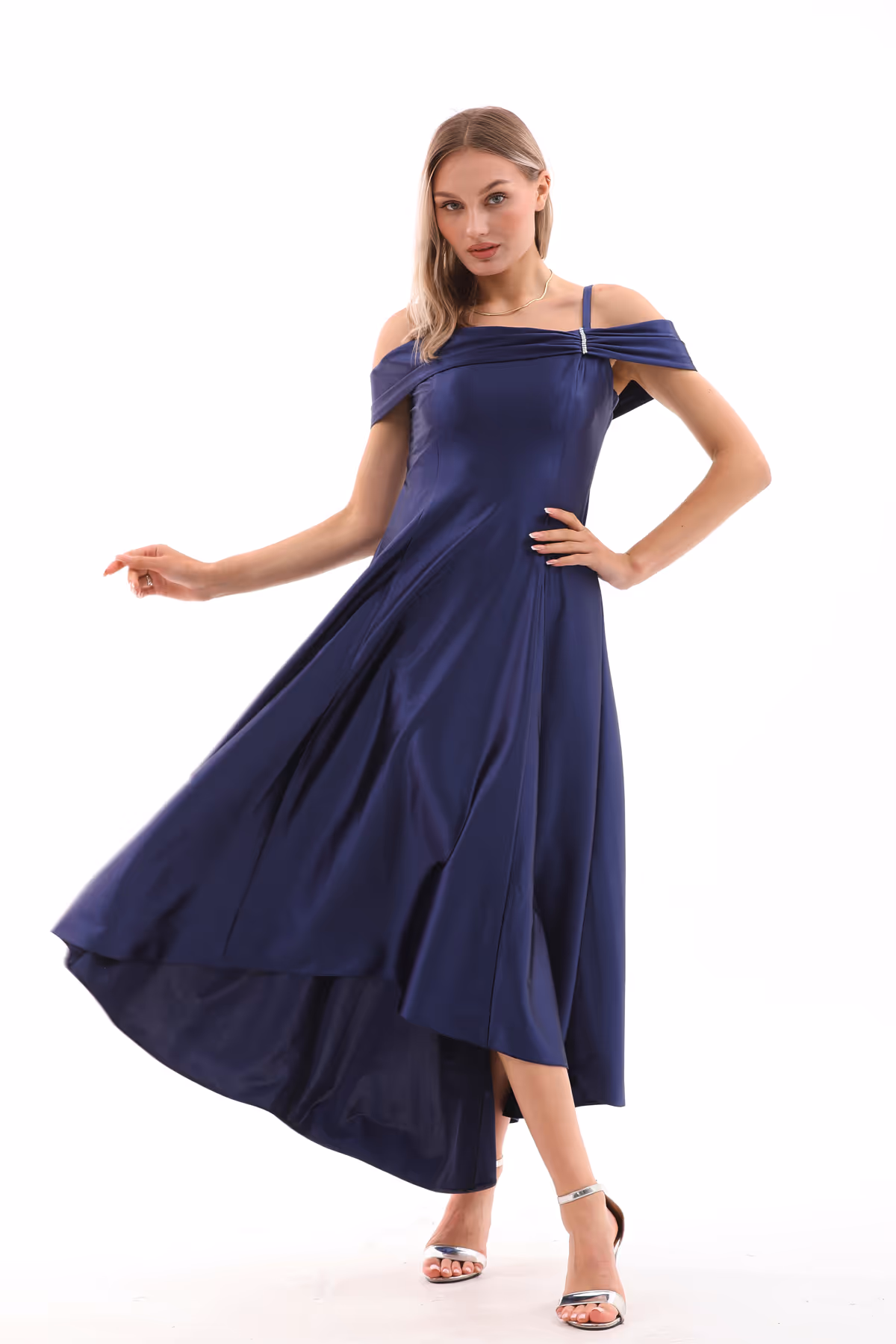 Model posing in the navy blue Valeria gown, showcasing its flowing A-line silhouette and crystal-trimmed neckline.