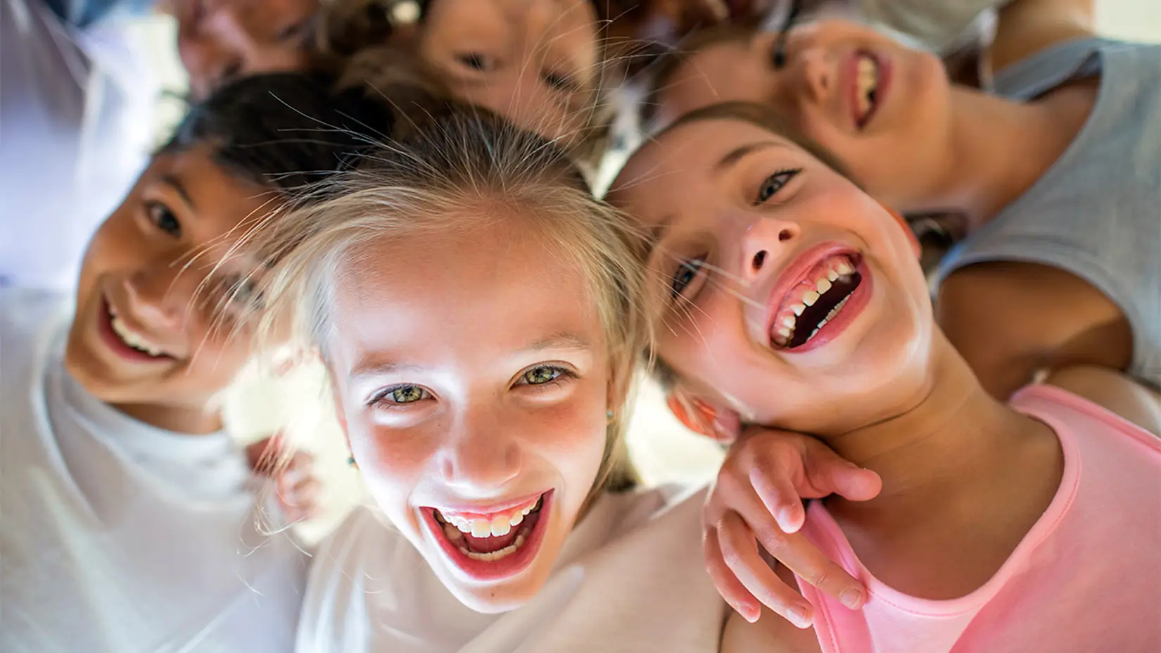 Kinder liegen sich lachend in den Armen