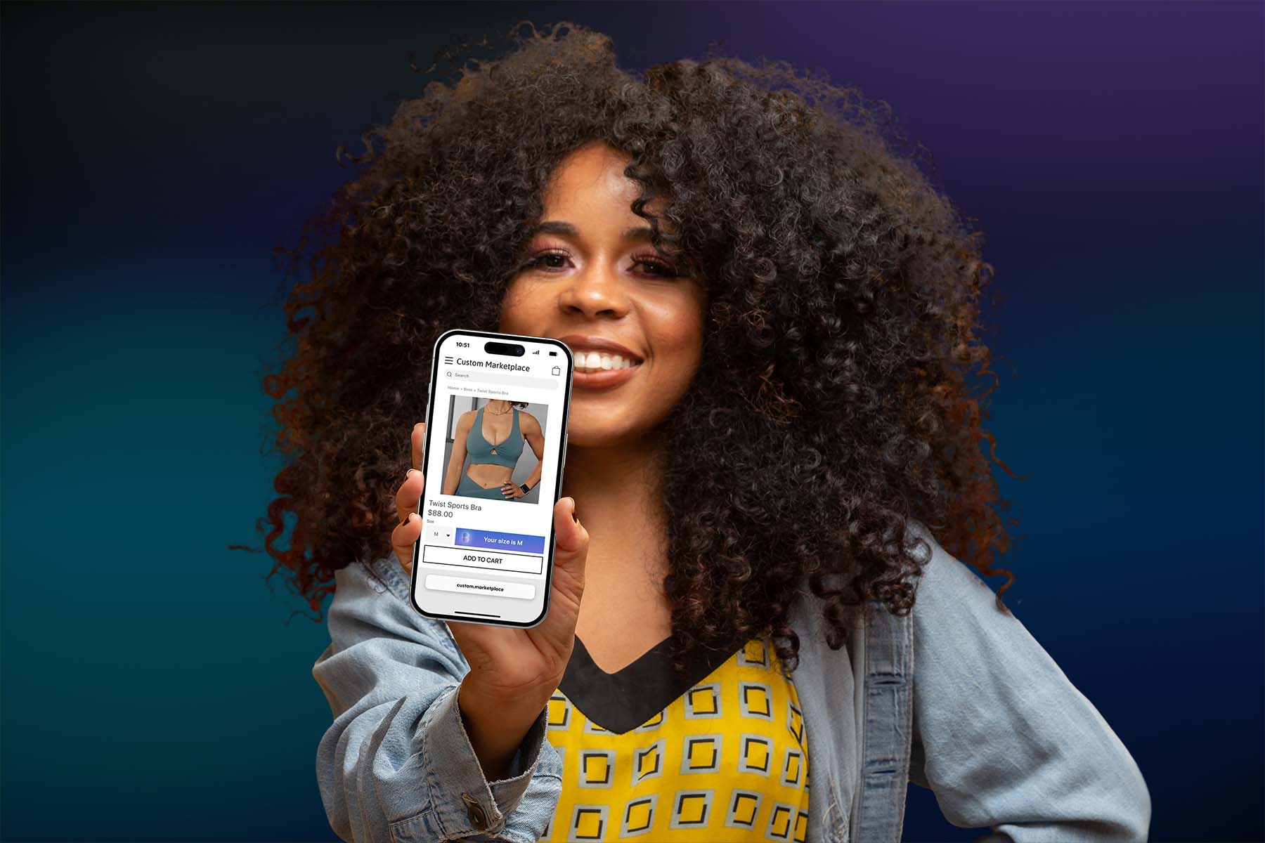 A woman holding a phone towards the camera, showing the product detail page for a sports bra