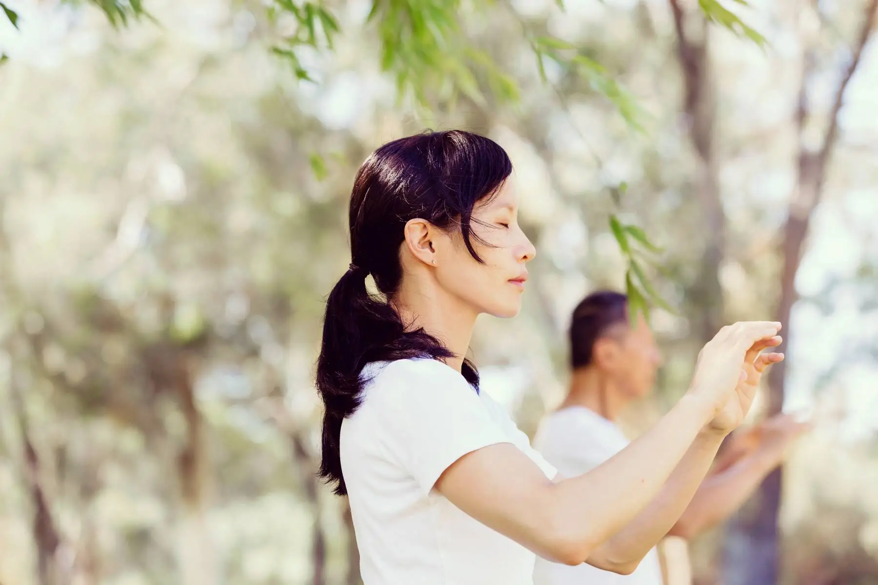 Une femme fait du qi gong dans la nature