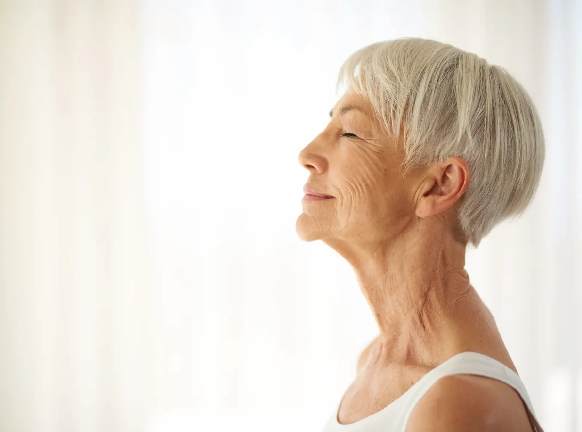 Une femme âgée sourit dans la lumière