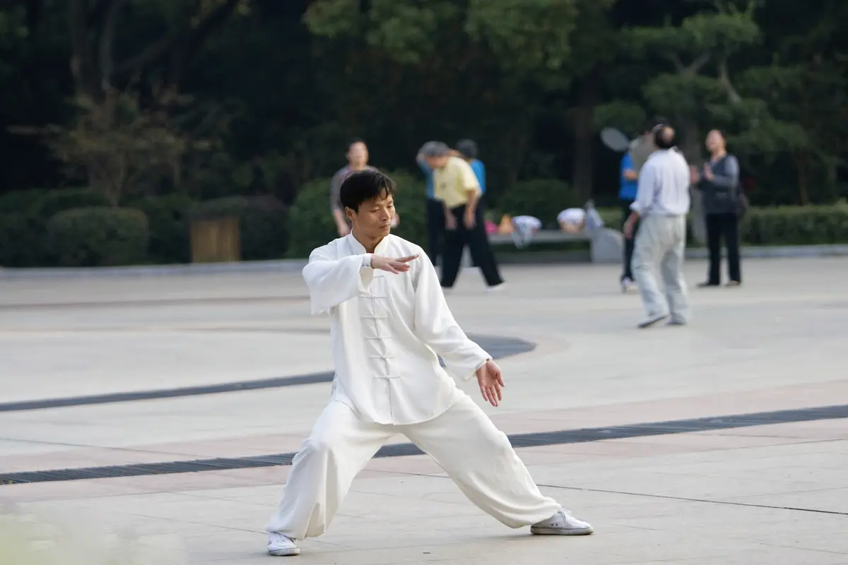 Un homme pratiquant le taiji quan dans un parc en Chine.