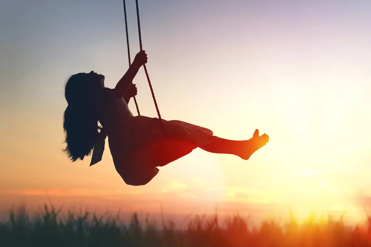 Une petite fille sur une balançoire dans la nature