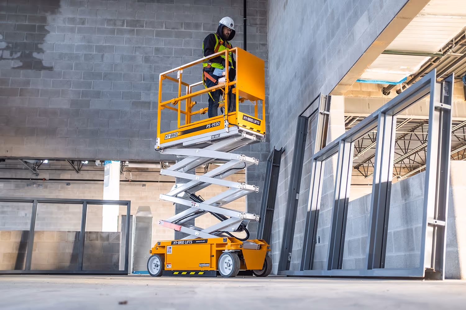 Construction worker on a scissor lift in a warehouse build project
