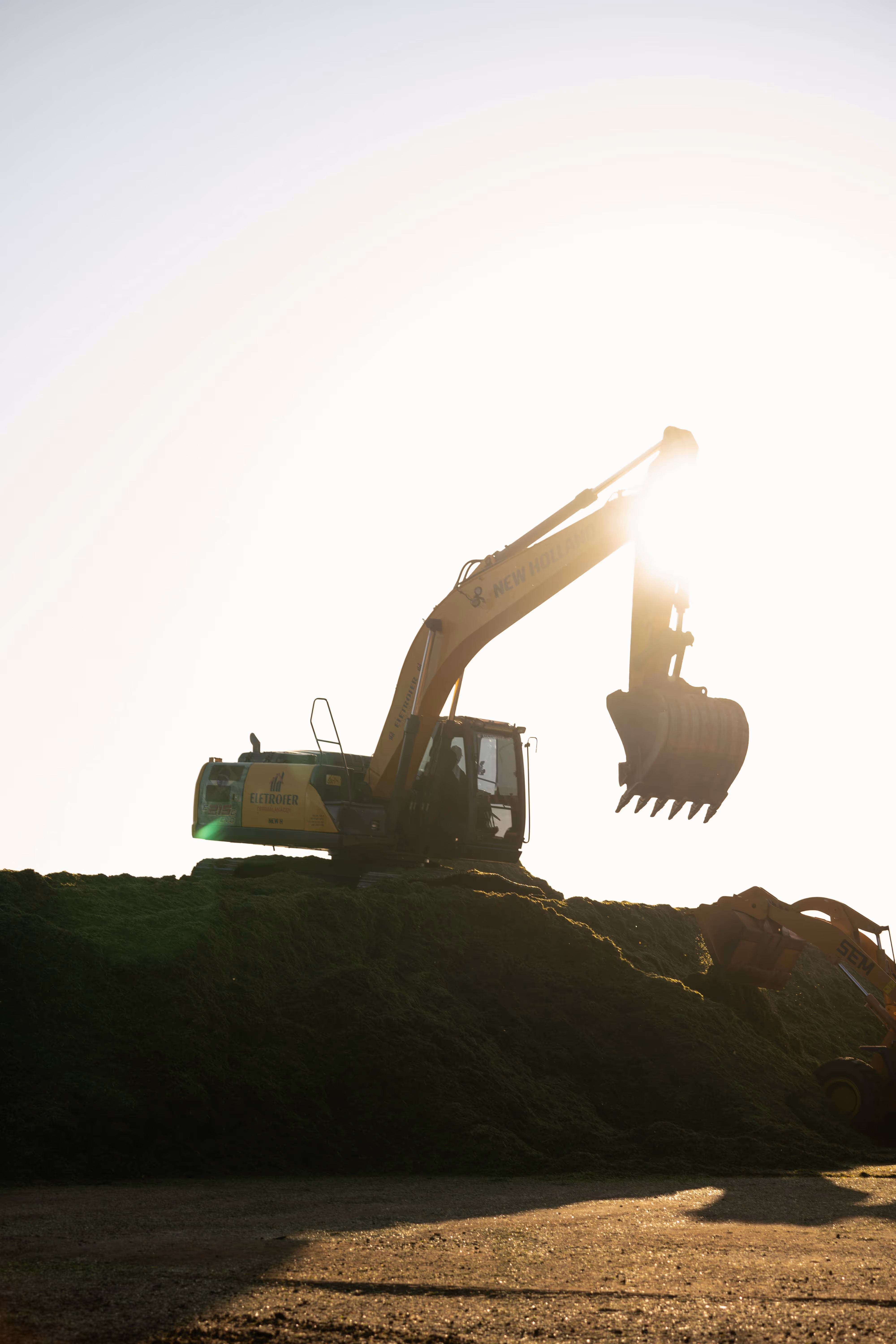 Excavator digger working with the sunset in the background