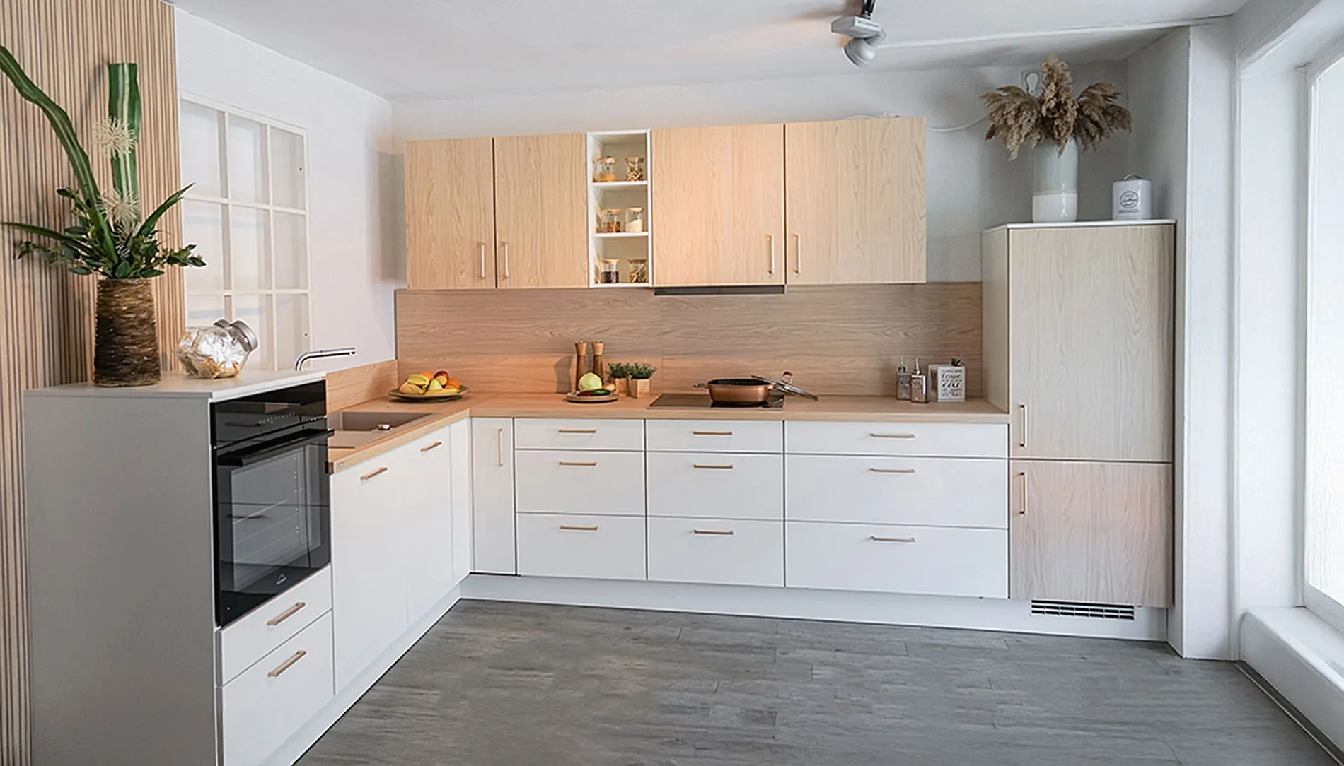 Helle Küche mit weißen Küchenschränken und Holzplatten.
