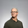 A man wearing glasses and a green shirt.