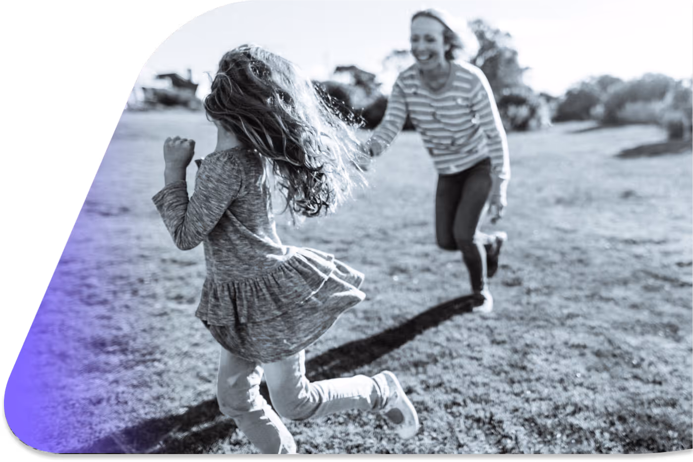 A woman and a little girl running in a field.